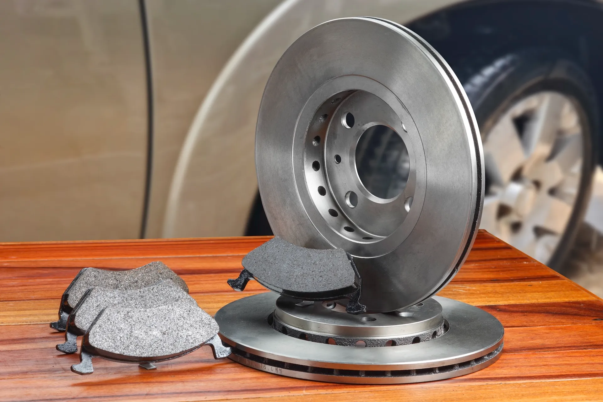 New vented disc rotors and brake pads laid out on a workshop bench