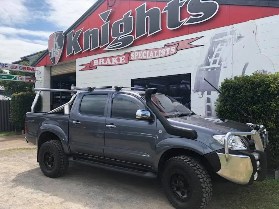 Boat and trailer being towed past the Knights Brake Specialists workshop in Cairns